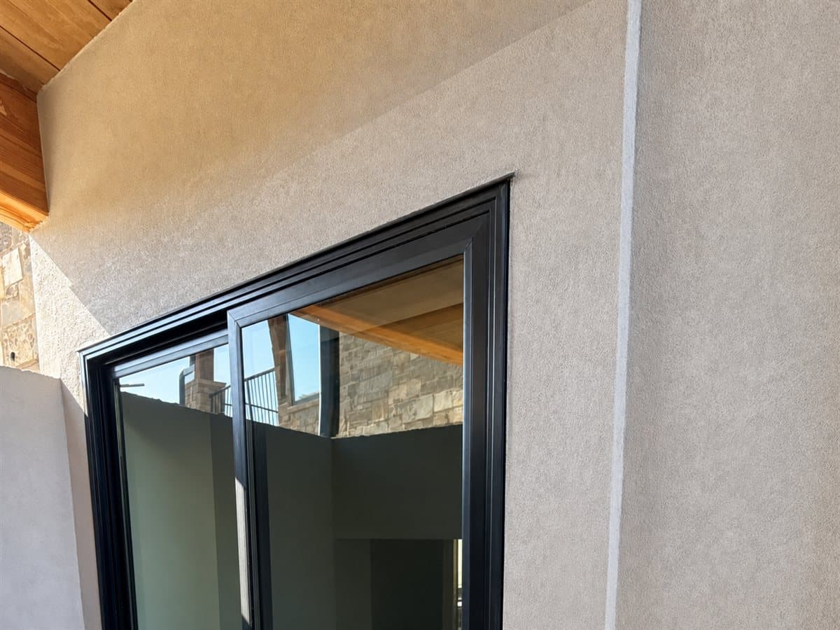 Smooth cream stucco finish beneath a warm wood soffit